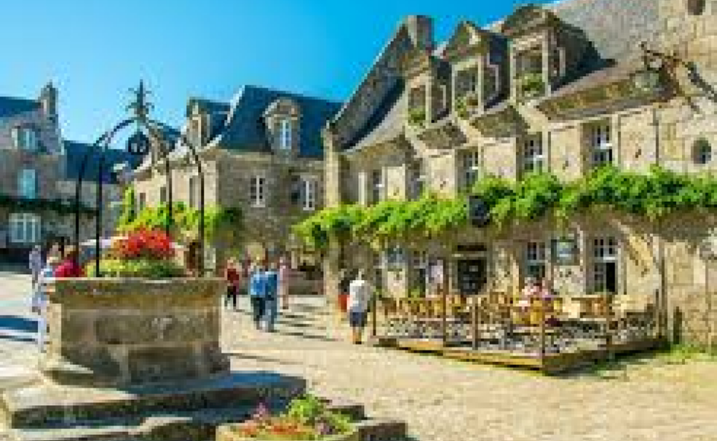 alt="contact harmony tech – place de village breton en pierres avec puits fleuri"