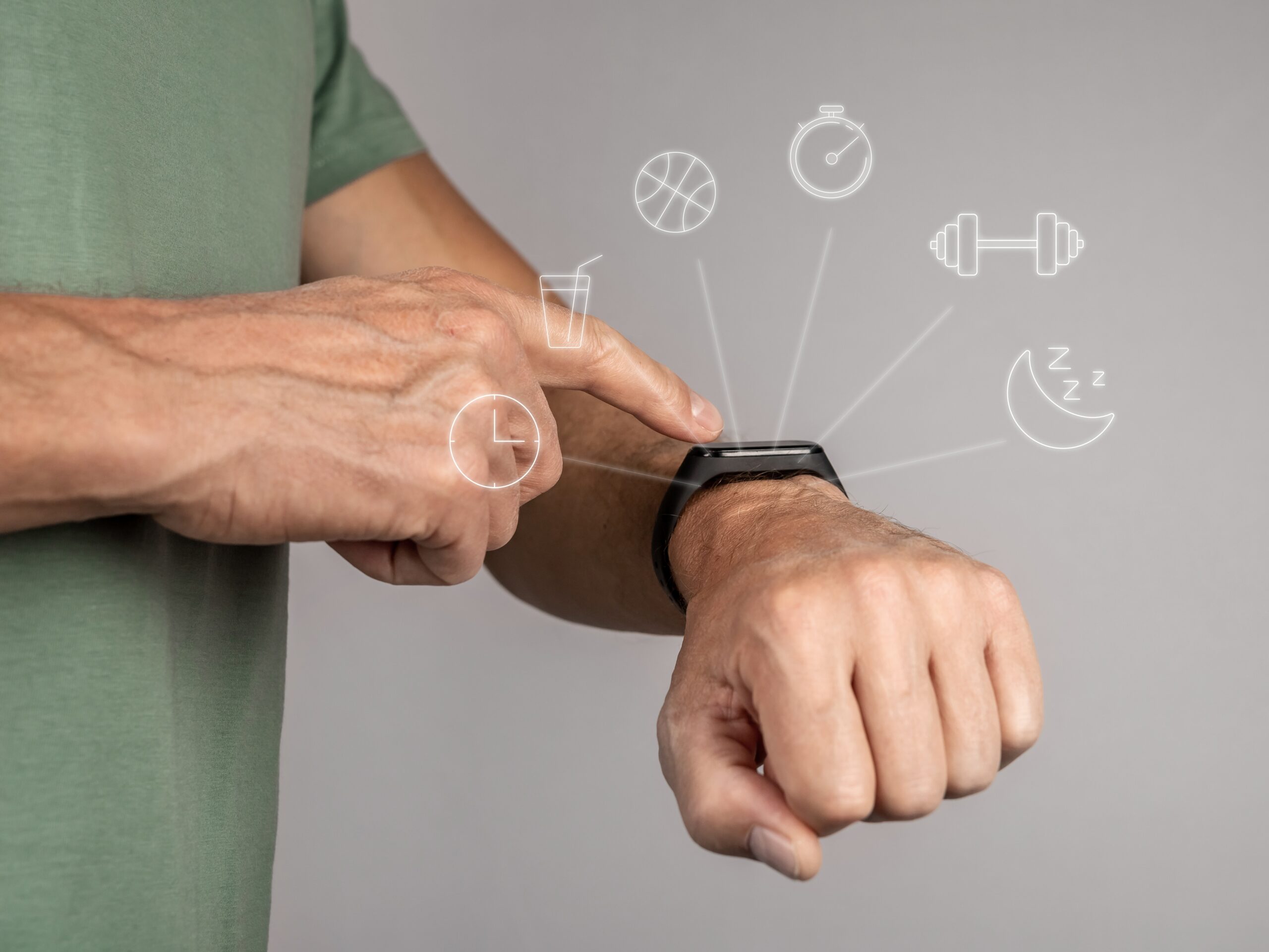 L'image montre une personne portant un bracelet connecté au poignet gauche et interagissant avec l'écran tactile de l'appareil à l'aide de son doigt droit. Autour du bracelet, des icônes translucides représentant diverses fonctionnalités s'affichent, telles qu'un ballon de basket pour l'activité physique, un chronomètre, une haltère pour les exercices de musculation, une lune pour le suivi du sommeil, une horloge, et un verre d'eau pour l'hydratation. La scène met en valeur les fonctionnalités multiples d'un bracelet connecté de fitness ou de santé.